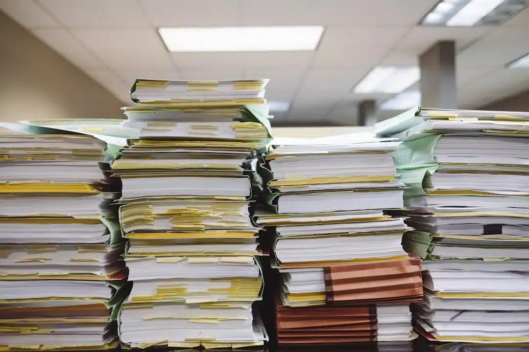 Paper files and documents representing business compliance and recordkeeping.